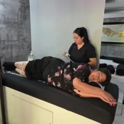 Foto de una mujer mayor recostada a punto de recibir tratamiento de fisioterapia en la clínica de rodilla en Guadalajara